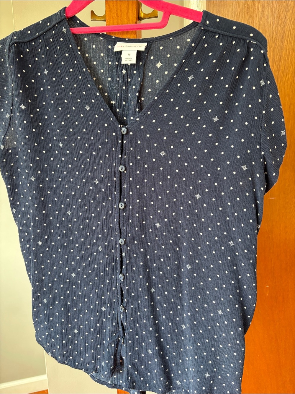 Navy blue white polka dot gauze type blouse pleated effect on back.